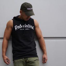 close up shot of a man with a hat hairstyle, wearing gym clothing and posing outside