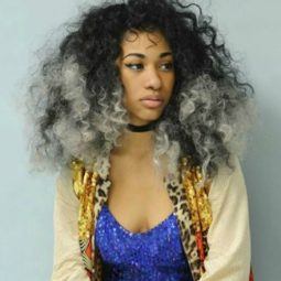 close up shot of woman with grey ombre natural hair, wearing blue top and jacket and necklace