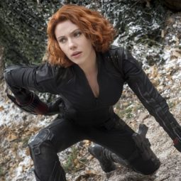 Marvel hairstyles: Scarlett Johansson with short wavy copper red bob wearing black jumpsuit.