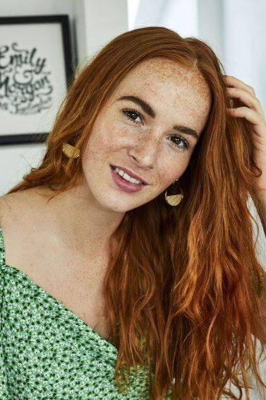 Woman touching her long red wavy hair