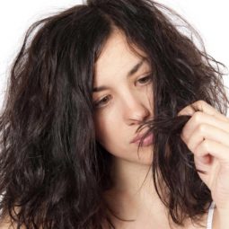 model looking at her brown frizzy hair