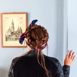 Crown hair: Close up shot of a woman with chestnut brown hair styled into a crown braid, complete with a hair scarf accessory