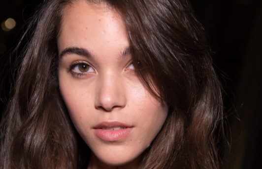 Hair thickening spray: close up beauty shot of a brunette model backstage at the balmain aw18 show with voluminous hair