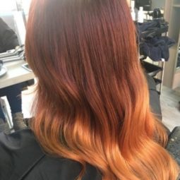 back view of a woman with glossy copper ombre hair