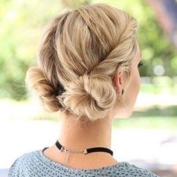 landscape shot of a blonde woman wearing a blue patterened top with her hair in twisted low macaron buns