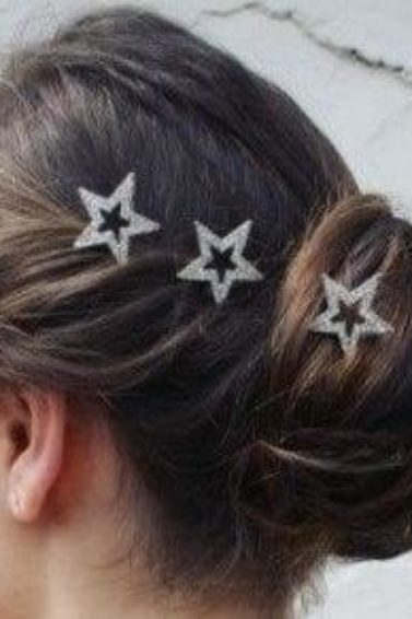 side view of a brunette woman with her hair in a twisted updo with star hair accessories