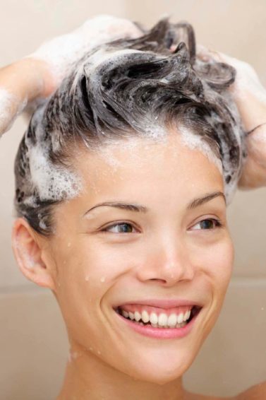 Woman lathering shampoo into her hair