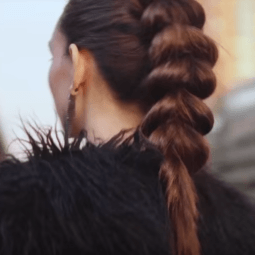 Pull through braid brunette girl standing outside with her back to camera