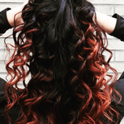 a red curly hair of a woman playing with her hair